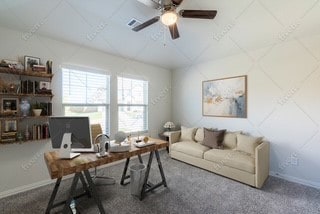 office space with ceiling fan and baseboards