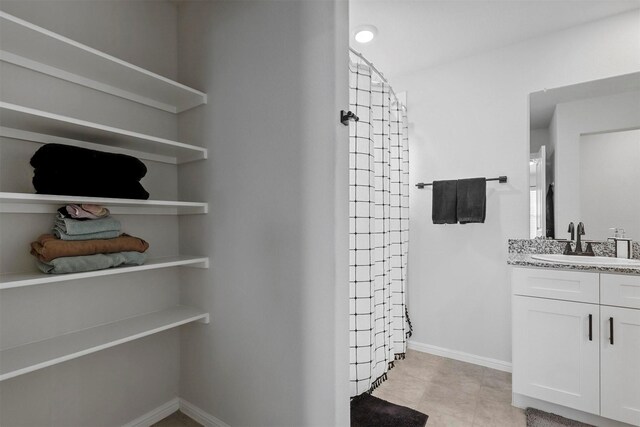 bathroom featuring vanity, tile patterned floors, and walk in shower