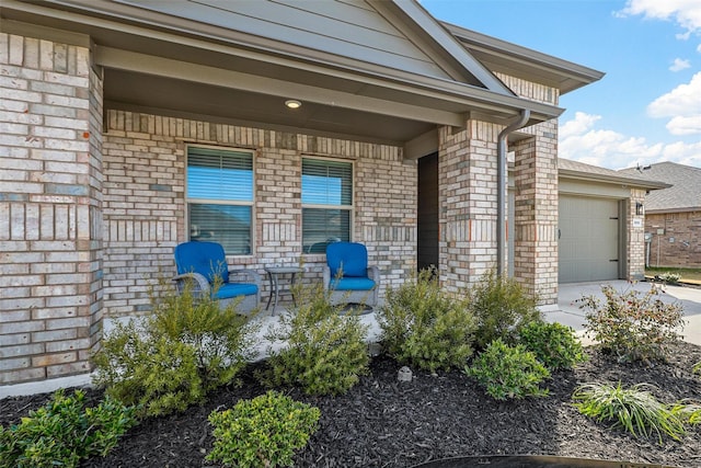 entrance to property featuring covered porch, brick siding, driveway, and an attached garage