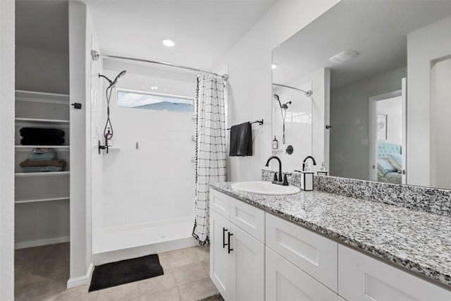 bathroom with baseboards, a shower stall, vanity, and tile patterned floors