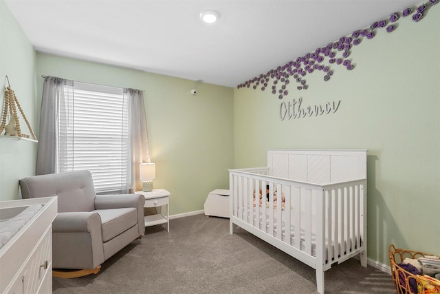 bedroom with carpet floors, a crib, and baseboards