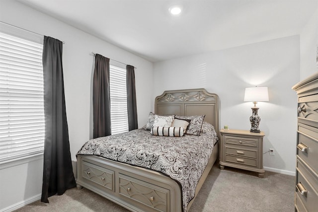 bedroom featuring light carpet and baseboards