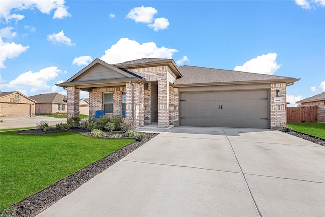 view of front of house with an attached garage, brick siding, driveway, and a front lawn