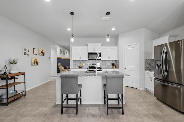 kitchen featuring stainless steel appliances, visible vents, a breakfast bar area, and white cabinetry