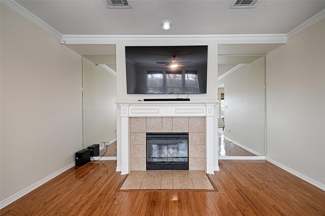 living room featuring a fireplace, crown molding, wood-type flooring, and ceiling fan