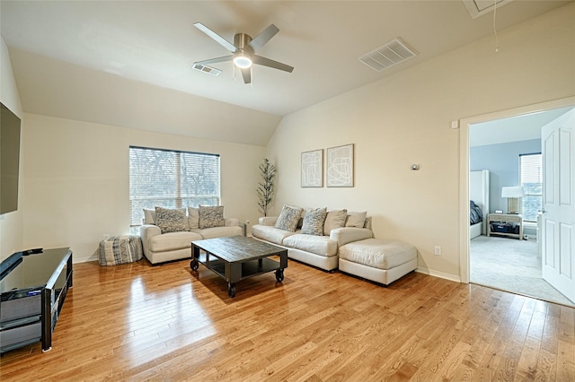 living room featuring vaulted ceiling, light hardwood / wood-style floors, and ceiling fan