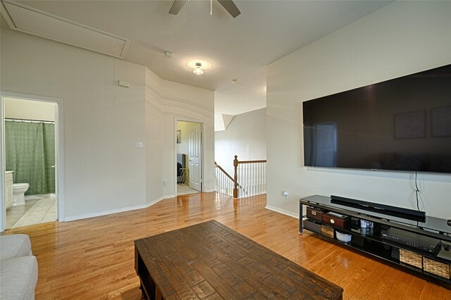 living room featuring ceiling fan, lofted ceiling, and light hardwood / wood-style flooring