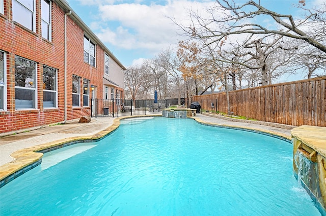 view of pool with a patio, pool water feature, and an in ground hot tub