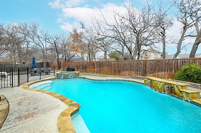 view of pool with a patio, pool water feature, and an in ground hot tub