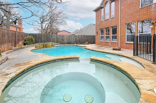 view of pool with pool water feature and an in ground hot tub