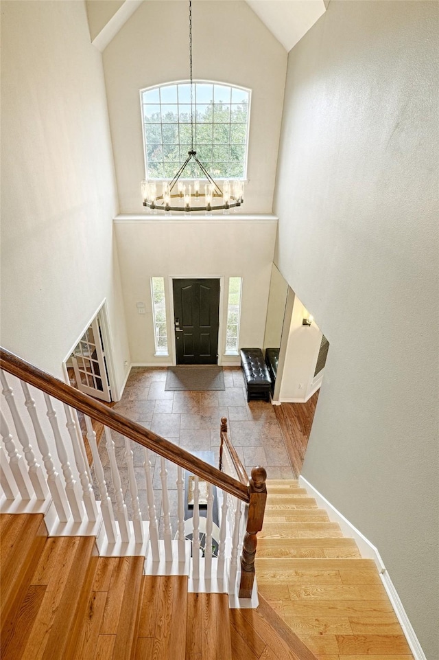 entrance foyer featuring a chandelier, high vaulted ceiling, and light hardwood / wood-style floors