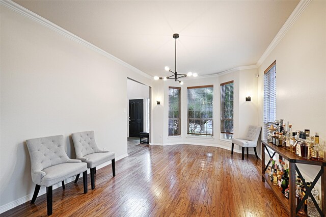 sitting room featuring crown molding, a chandelier, and hardwood / wood-style floors