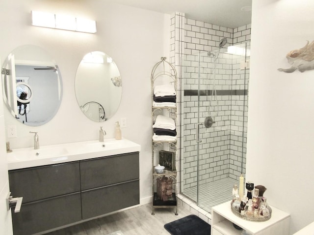 625 E Whitney St, Hamilton, TX 76531 - bathroom with a shower stall, wood finished floors, and double vanity