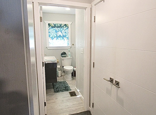 bathroom featuring vanity, wood-type flooring, and toilet