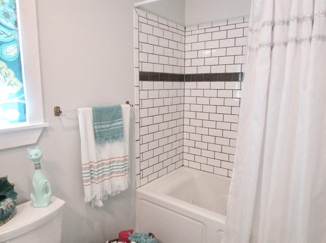 bathroom featuring shower / bath combination with curtain and toilet