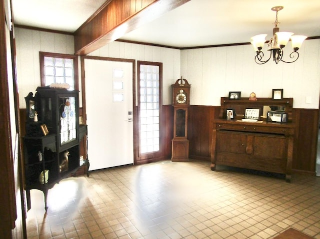 625 E Whitney St, Hamilton, TX 76531 - foyer entrance with a chandelier, crown molding, wood walls, and tile patterned flooring
