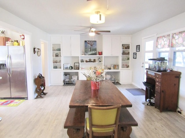 dining space with light hardwood / wood-style floors and ceiling fan