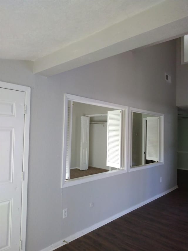 unfurnished room with lofted ceiling and dark hardwood / wood-style floors