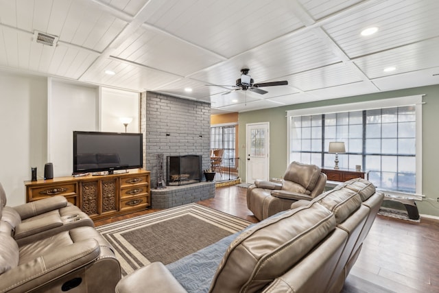 living room with wood-type flooring, ceiling fan, and a fireplace