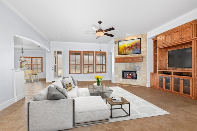 living room with light tile patterned flooring, a fireplace, ornamental molding, ceiling fan, and built in shelves