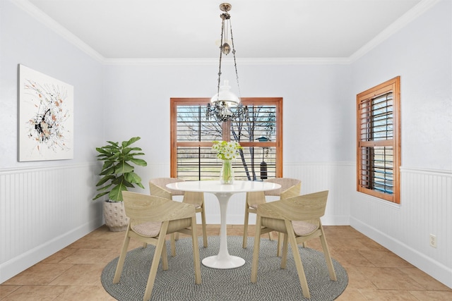 dining area with an inviting chandelier, ornamental molding, and light tile patterned floors