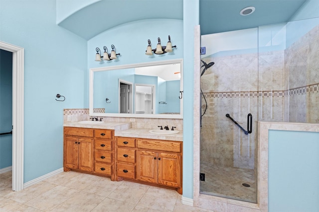 bathroom featuring vanity, tile patterned flooring, decorative backsplash, and walk in shower