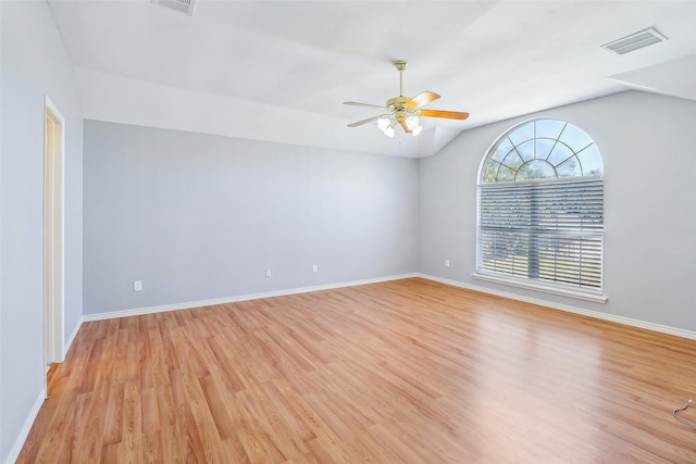 empty room with ceiling fan, lofted ceiling, and light wood-type flooring