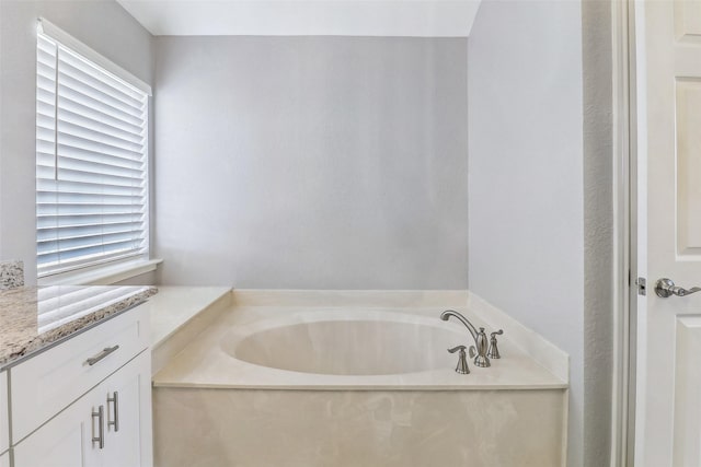 bathroom with a bathing tub, plenty of natural light, and vanity