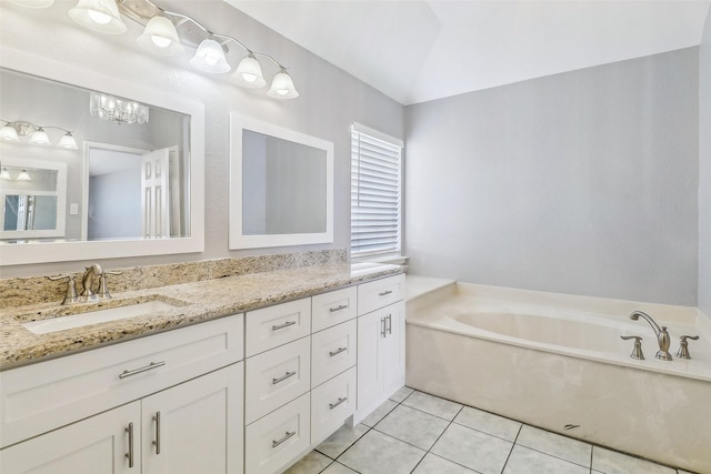 bathroom featuring tile patterned flooring, vanity, lofted ceiling, and a washtub