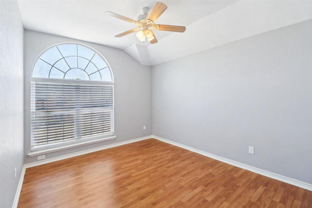 spare room with hardwood / wood-style flooring, lofted ceiling, and ceiling fan