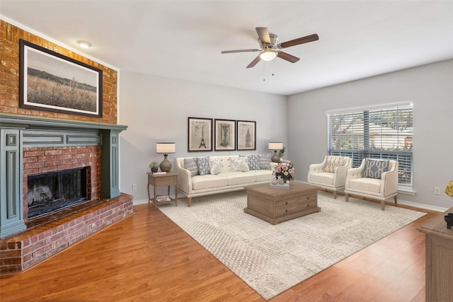 living room featuring ceiling fan, hardwood / wood-style floors, and a fireplace