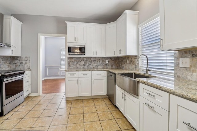 kitchen featuring white cabinetry, appliances with stainless steel finishes, sink, and light tile patterned floors