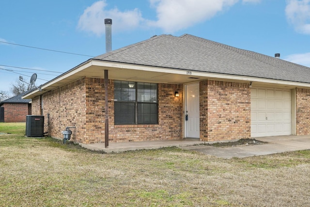 single story home featuring central AC unit, a garage, and a front yard