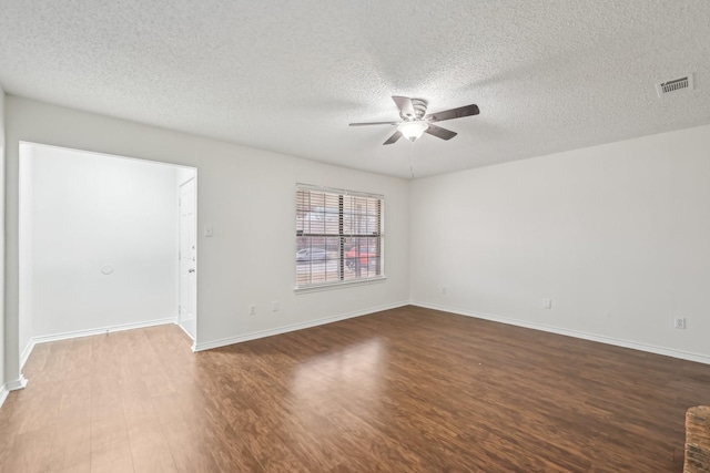 spare room featuring ceiling fan, dark hardwood / wood-style flooring, and a textured ceiling