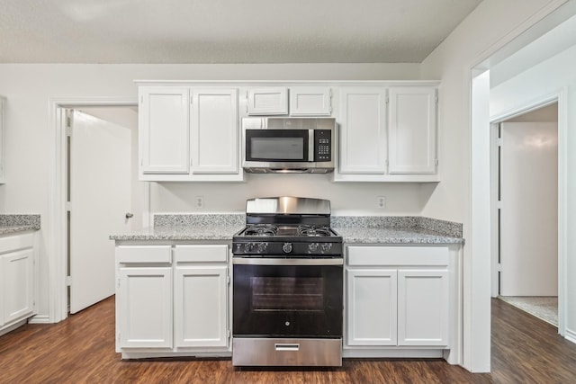 kitchen featuring white cabinetry, dark hardwood / wood-style flooring, light stone counters, and range with gas cooktop