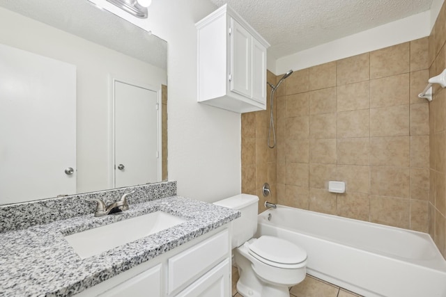 full bathroom featuring tile patterned floors, toilet, tiled shower / bath, a textured ceiling, and vanity