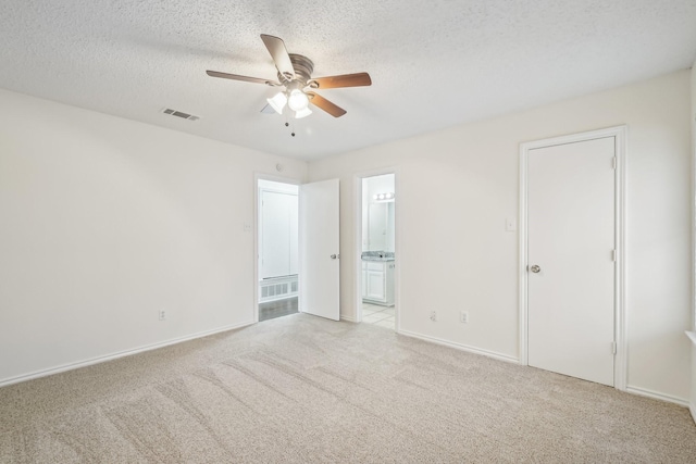 carpeted empty room with ceiling fan and a textured ceiling