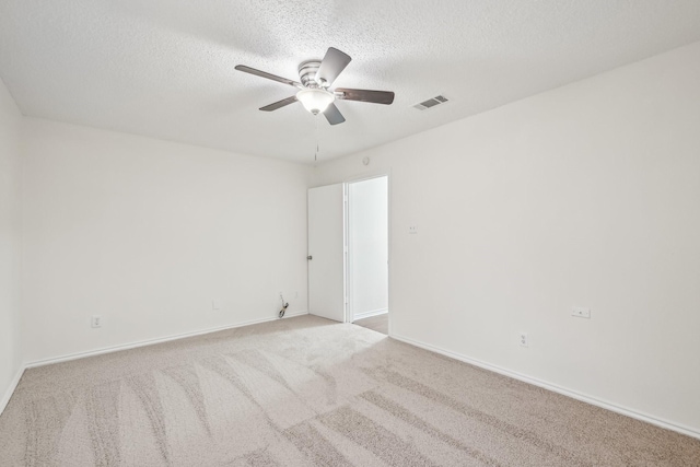 carpeted empty room featuring ceiling fan and a textured ceiling