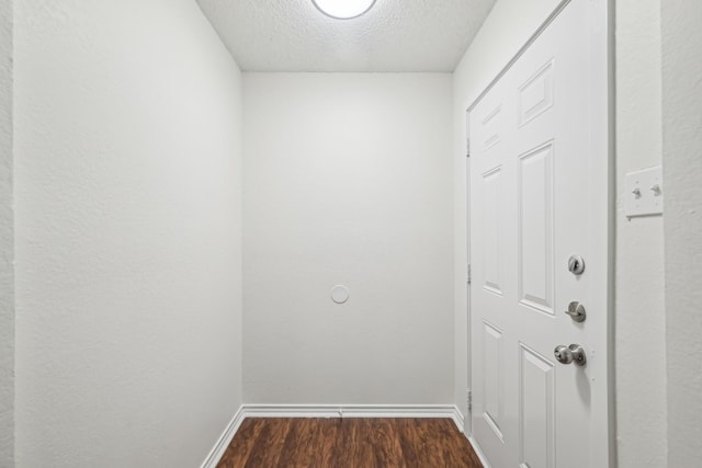 entryway with a textured ceiling and dark hardwood / wood-style flooring