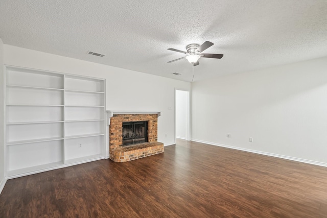 unfurnished living room featuring a textured ceiling, dark hardwood / wood-style floors, built in features, ceiling fan, and a fireplace