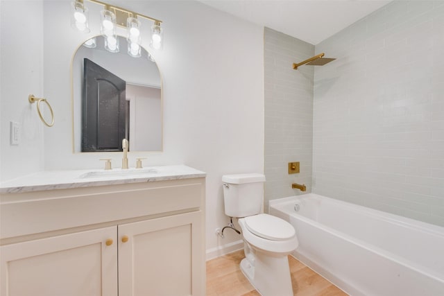 full bathroom featuring hardwood / wood-style flooring, vanity, tiled shower / bath combo, and toilet