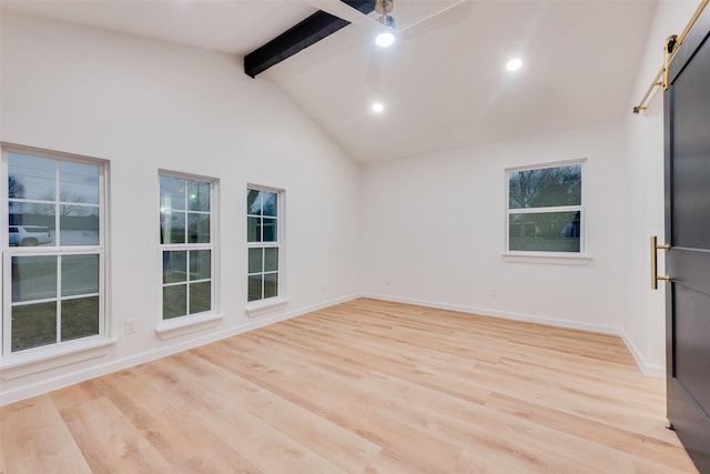 unfurnished room with high vaulted ceiling, beam ceiling, light hardwood / wood-style floors, and a barn door