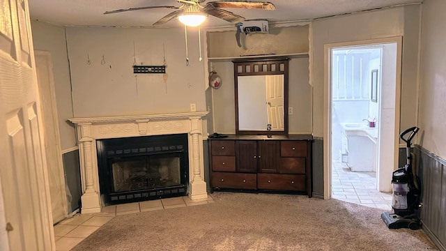 living room featuring light carpet, light tile patterned floors, a fireplace with flush hearth, and a ceiling fan