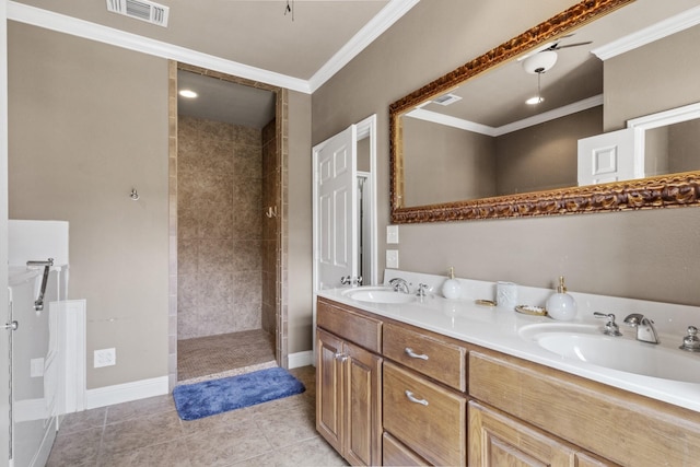 bathroom featuring a tile shower, vanity, tile patterned flooring, and crown molding