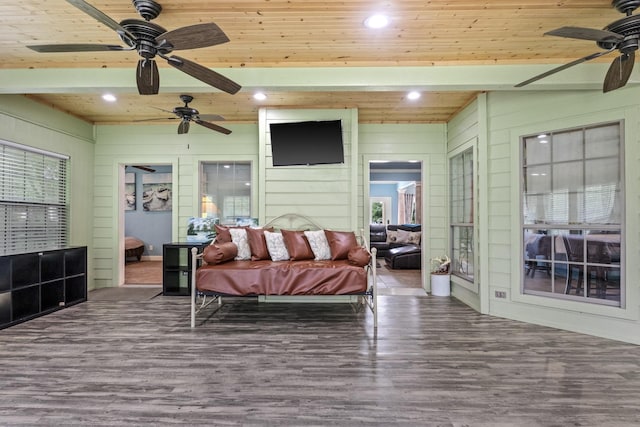 bedroom with wood ceiling, ceiling fan, wood-type flooring, and wooden walls