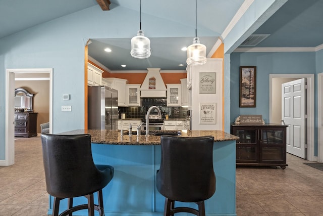 kitchen with decorative light fixtures, white cabinetry, vaulted ceiling with beams, decorative backsplash, and stainless steel fridge with ice dispenser