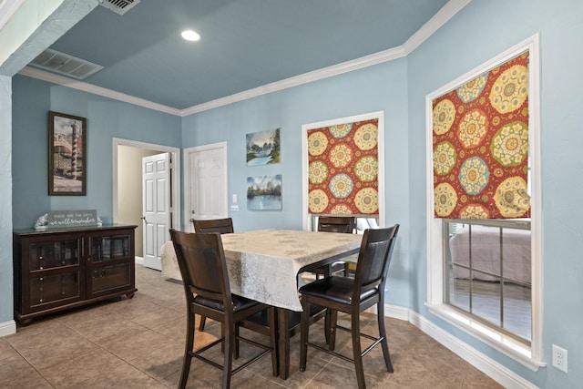 dining space with ornamental molding and light tile patterned floors