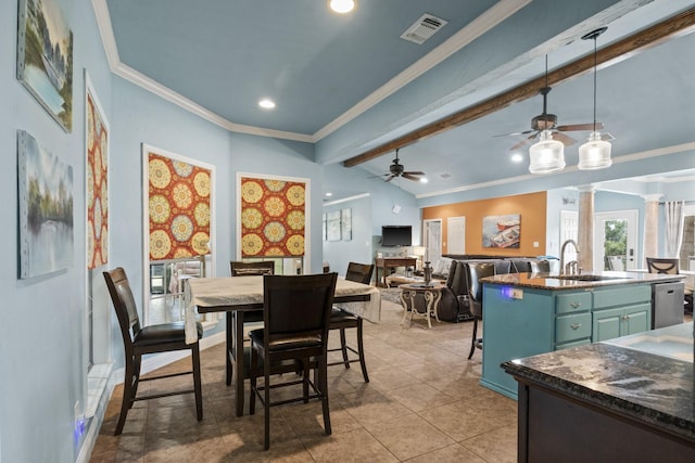 dining room featuring sink, crown molding, lofted ceiling with beams, and ornate columns