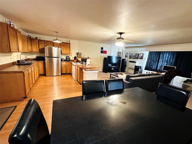 interior space featuring ceiling fan, sink, a textured ceiling, and light hardwood / wood-style floors