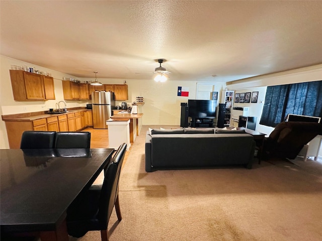 carpeted living room with sink, a textured ceiling, and ceiling fan